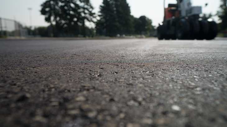 Close up shot of asphalt with the sun glinting off of its surface.